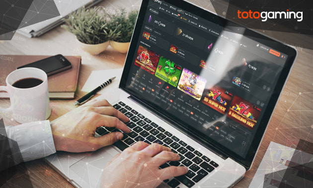 Un laptop care afișează site-ul web al cazinoului online TotoGaming cu o selecție de jocuri.
