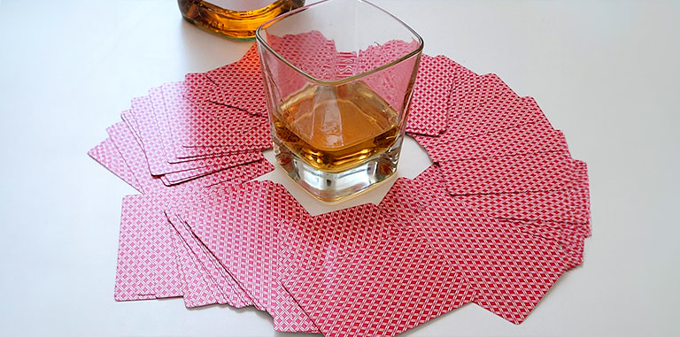 Un pachet de cărți și un pahar cu whisky