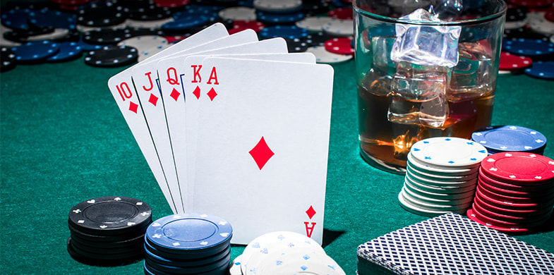 Masa de poker cu jetoane, cărți și băutură